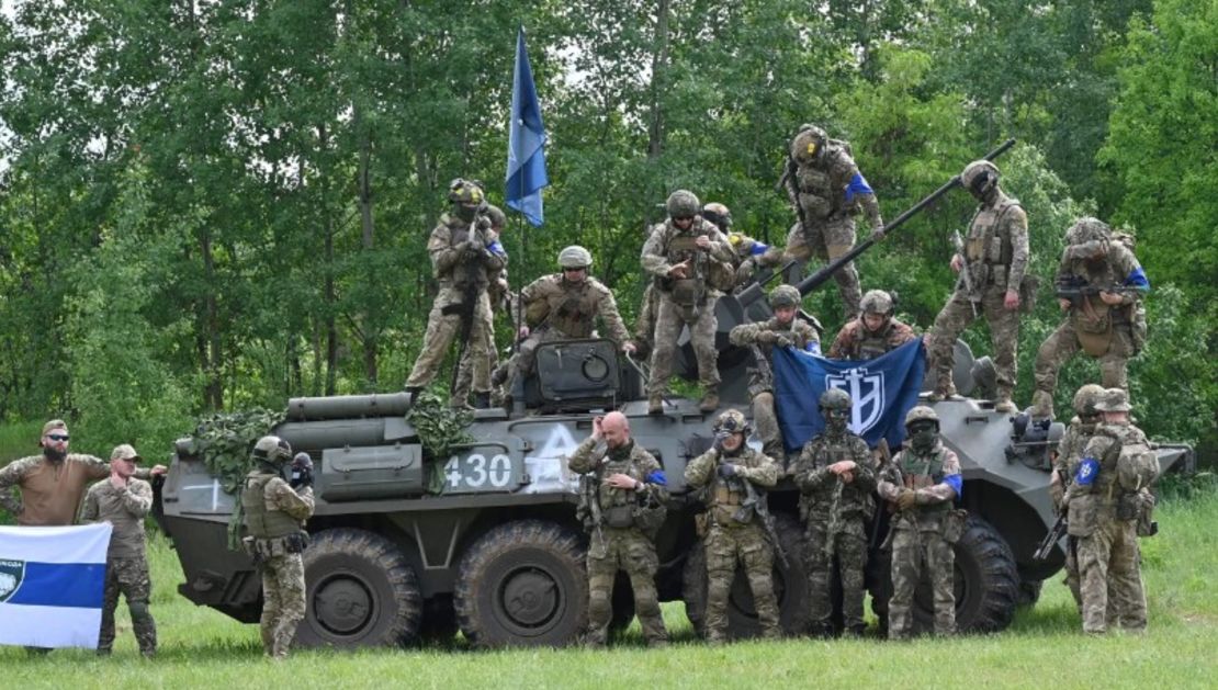 Combatientes del Cuerpo de Voluntarios de Rusia y del grupo aliado Legión para la Libertad de Rusia junto a un vehículo blindado de transporte de tropas incautado el 24 de mayo de 2023.