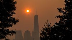 JERSEY CITY, NEW JERSEY - JUNE 8: The sun rises behind the One World Trade Center in New York, while the smoke from Canada wildfires covers the Manhattan borough as it is seen from Liberty State Park on June 8, 2023 in New Jersey.