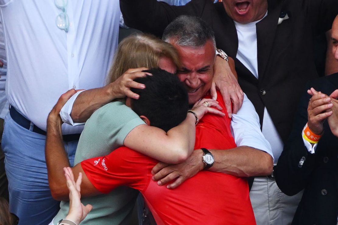 Djokovic de Serbia se abraza con los padres Dijana Dokovic y Srdjan Djokovic después de ganar el campeonato. Crédito: Clive Mason/Getty Images