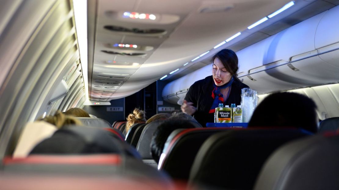 Una azafata sirve bebidas a los pasajeros a bordo de un vuelo de American Airlines desde el Aeropuerto Internacional de Dallas/Fort Worth.