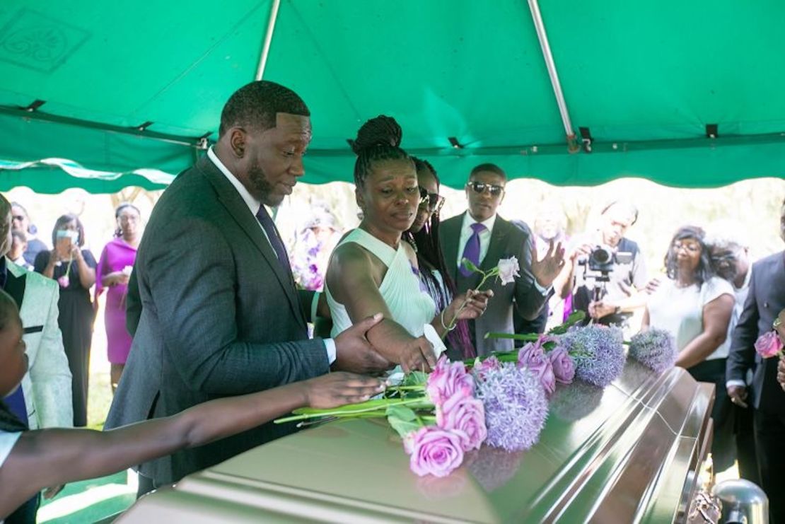 Pamela Dias, la madre de Ajike Owens, centro, pone rosas en el ataúd durante el funeral de Owens, el 12 de junio de 2023.