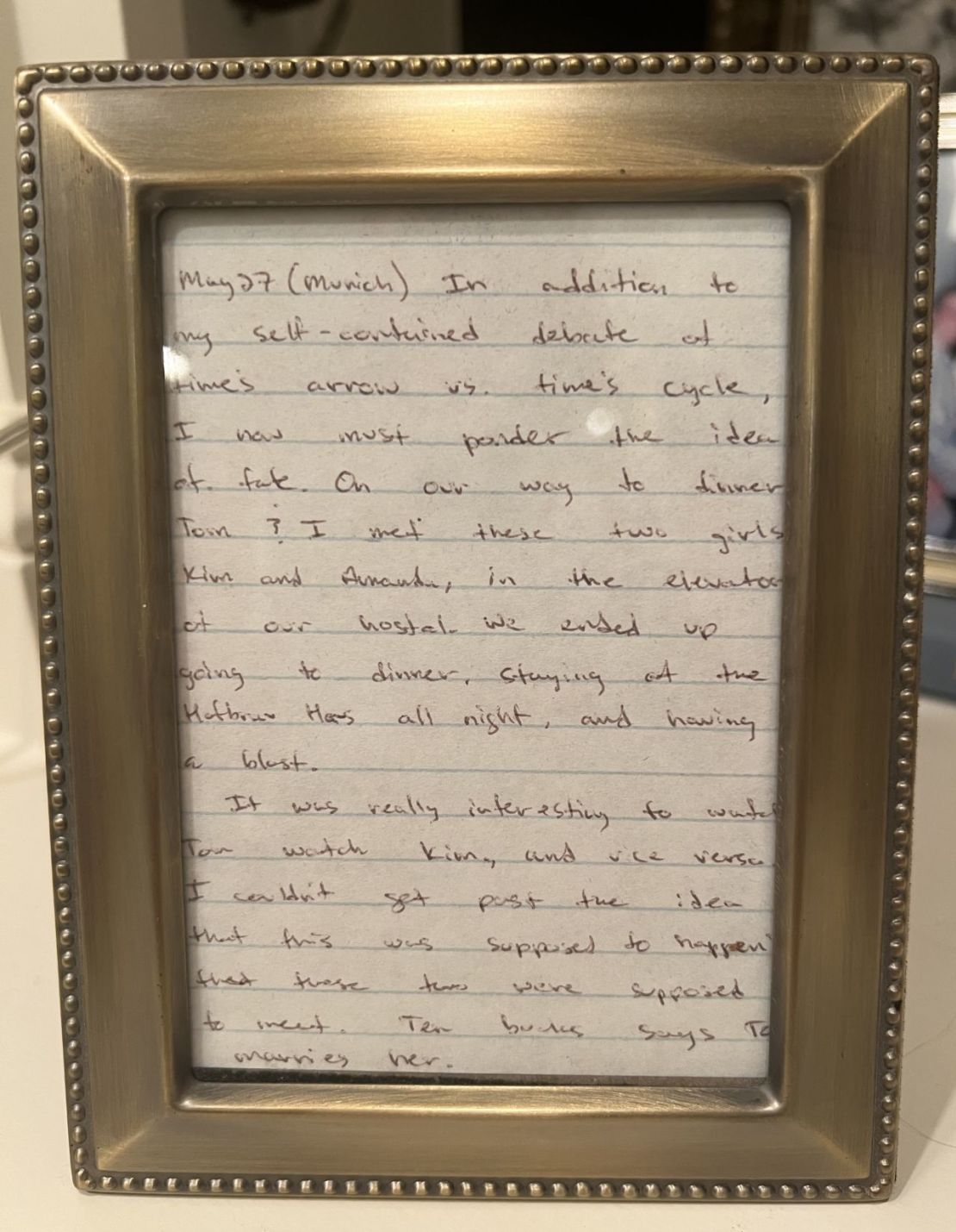 Un fragmento enmarcado del diario de viaje de John, que describe el momento en que Tom y Kim se conocieron. "Diez dólares a que Tom se casa con ella", escribió John aquel día de 1998. Crédito: Kim Latkovic