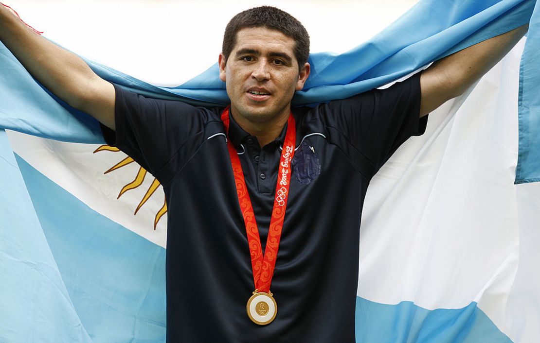 El mediocampista argentino Juan Riquelme, envuelto en su bandera nacional, posa durante la ceremonia de entrega de medallas del torneo olímpico de fútbol masculino en el estadio nacional de Beijing durante los Juegos Olímpicos de Beijing 2008 el 23 de agosto de 2008. Argentina ganó el oro por delante de Nigeria y Brasil.