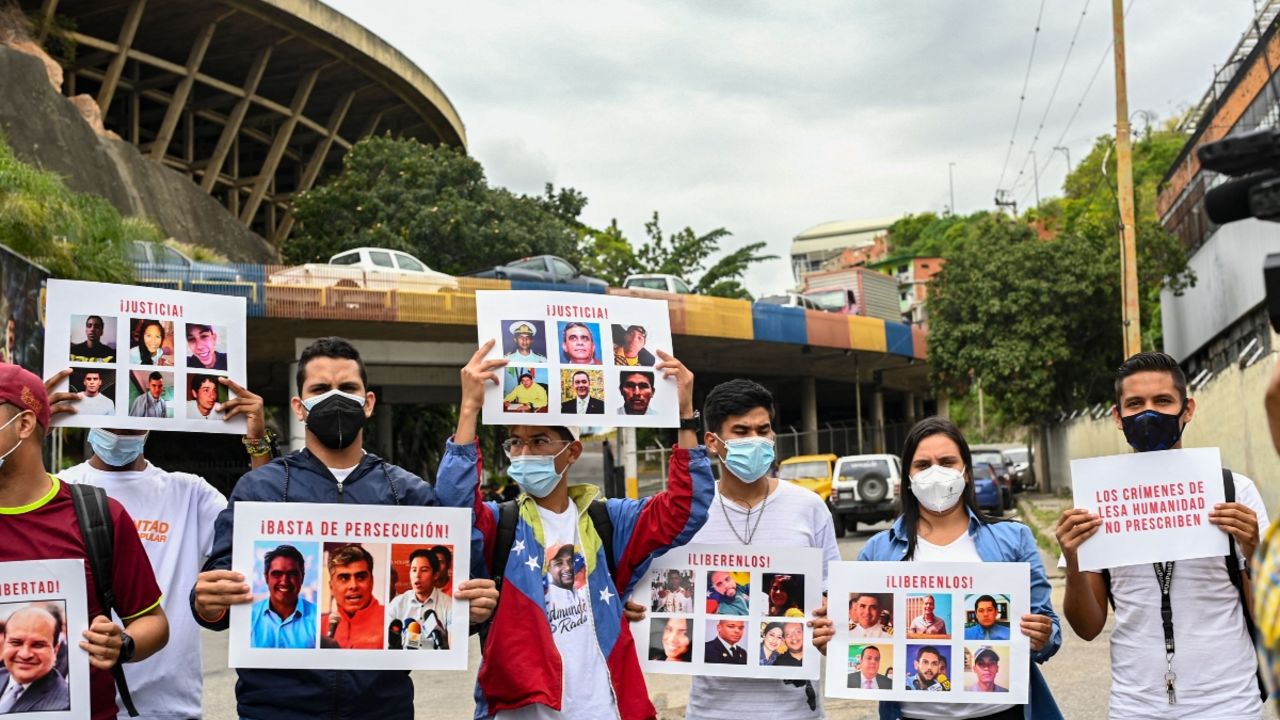 Familiares de presos políticos portan carteles con sus fotos llamando la atención del fiscal de la Corte Penal Internacional (CPI), Karim Khan, durante una protesta para exigir su libertad frente a la cárcel de El Helicoide en Caracas, el 3 de noviembre de 2021.