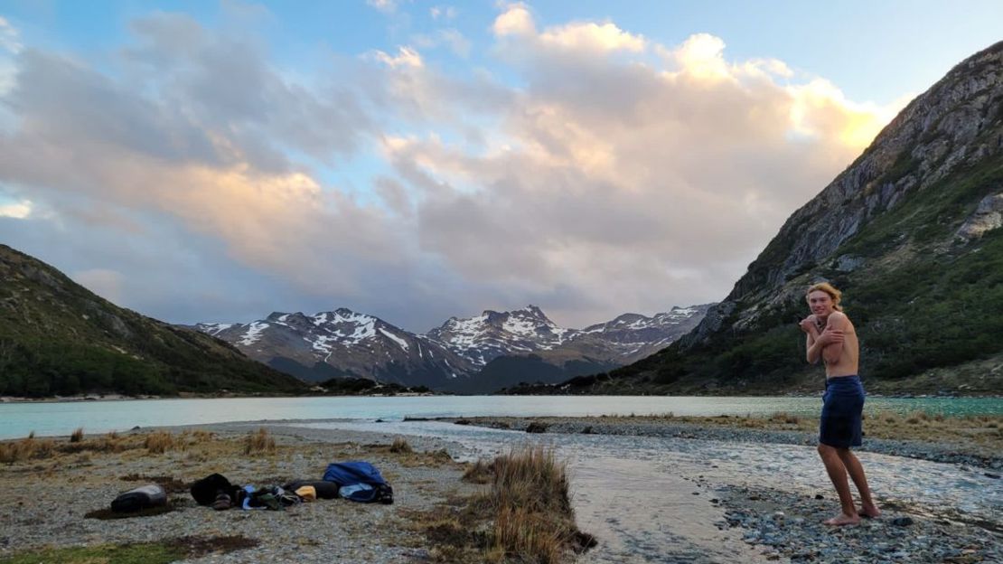 Tras dos años en la carretera, por fin ha completado el viaje con el que soñó durante años. Aquí aparece limpiándose en un arroyo alimentado por un glaciar en Ushuaia, Argentina. Cortesía: Adam Swanson