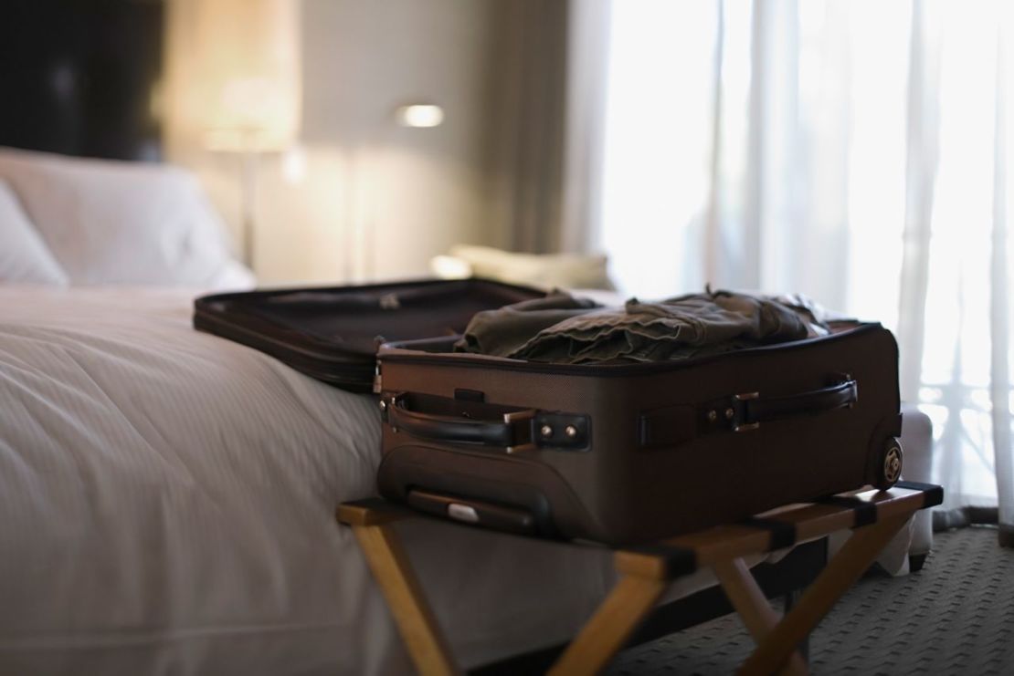 En una habitación de hotel, coloca tu equipaje en un estante, como ves arriba. Sin embargo, aléjalo de la cama. Esta maleta está demasiado cerca de la cama. Si hay bichos en el colchón, podrían llegar al equipaje. Crédito: Jupiterimages/Stockbyte/Getty Images