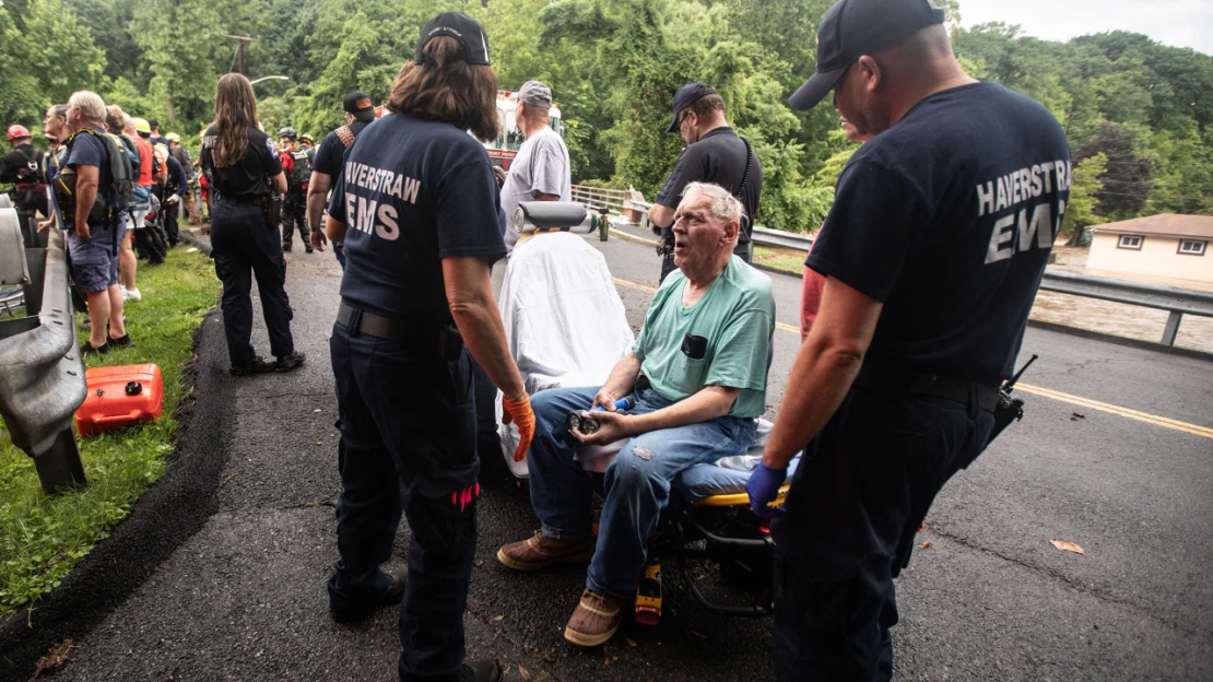 El personal de emergencia atiende a un residente de una vivienda en Stony Point, Nueva York, tras rescatarlo de su casa inundada este domingo.