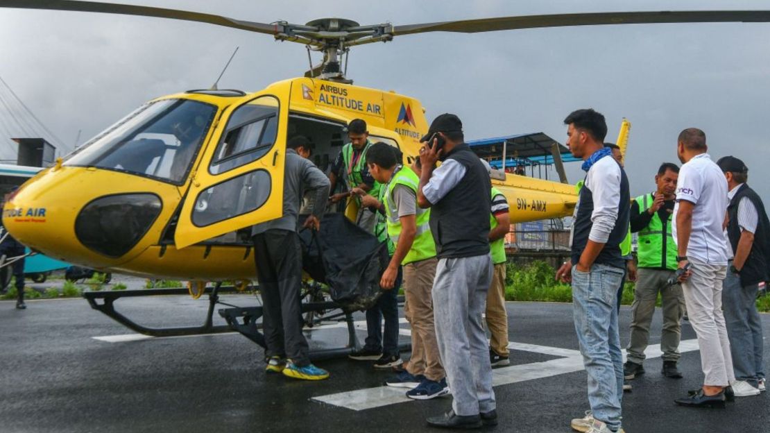 En el Hospital Universitario Tribhuvan de Katmandú, varias personas bajan el cuerpo de una víctima fallecida en un accidente de helicóptero en Nepal este martes 11 de julio de 2023. Las seis personas que iban a bordo de un helicóptero turístico en Nepal murieron al estrellarse poco después de despegar en la región del Everest el 11 de julio, según informaron las autoridades de aviación.