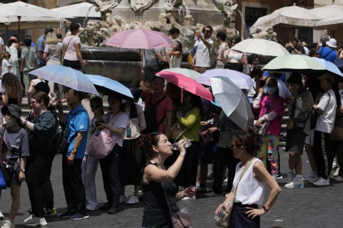 Los turistas usan sombrillas para protegerse del sol mientras hacen fila para ingresar al Panteón en Roma, el 8 de julio de 2023. Gregorio Borgia/AP