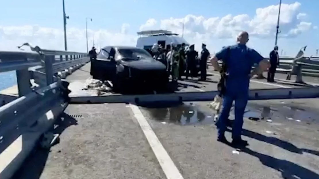 Investigadores rusos se reúnen cerca de un auto destruido en la sección dañada del puente el 17 de julio de 2023. Crédito: Comité de Investigación de Rusia/Reuters