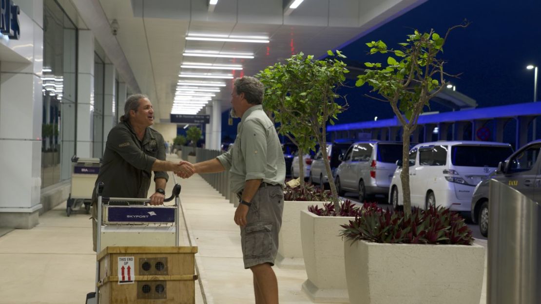 Gerardo García (izquierda) saluda al ecologista Mark Outerbridge a su llegada a las Bermudas con la caja de caracoles en peligro de extinción.