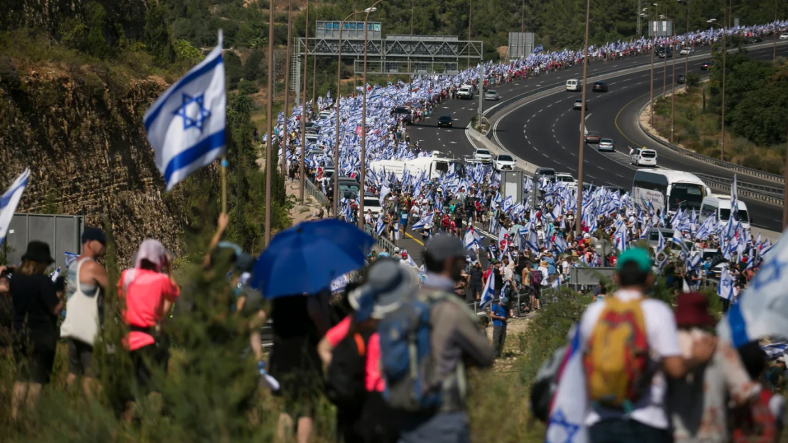 Miles de israelíes marchan hacia Jerusalén sosteniendo la bandera de Israel para protestar contra el plan de reforma del gobierno.