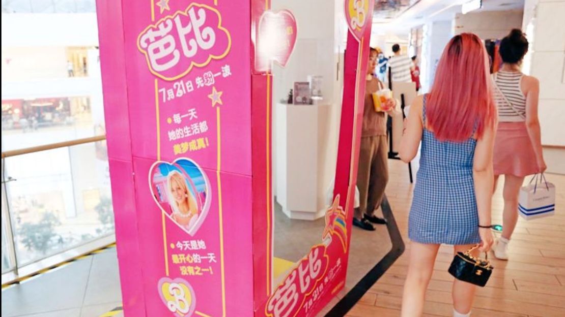 Asistentes pasan un cartel de "Barbie" en un cine en Shanghái, China, el 22 de julio.
