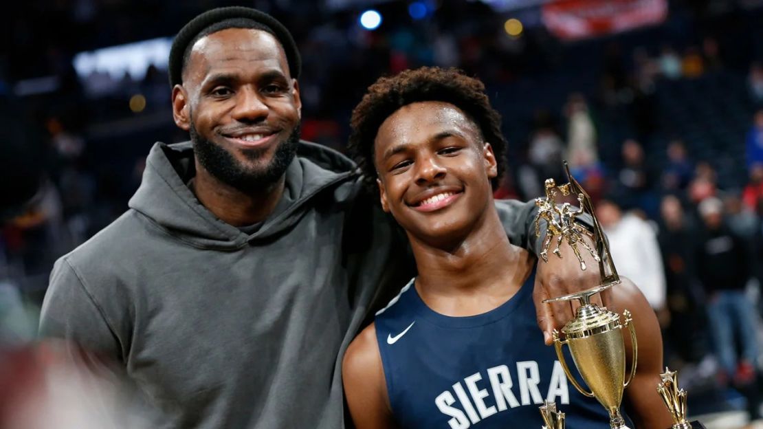 LeBron James, a la izquierda, posa con su hijo Bronny después de que Sierra Canyon venciera a Akron St. Vincent - St. Mary en un partido de baloncesto de instituto el 14 de diciembre de 2019, en Columbus, Ohio. Crédito: Jay LaPrete/AP