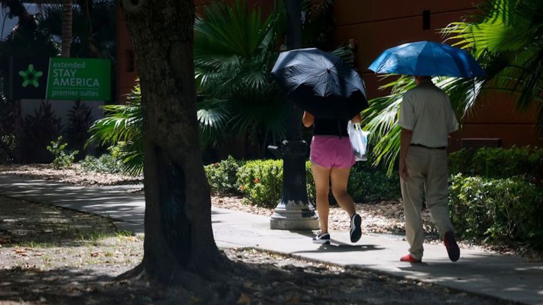 Los peatones llevan paraguas durante una ola de calor en Miami, Florida, el 25 de julio.