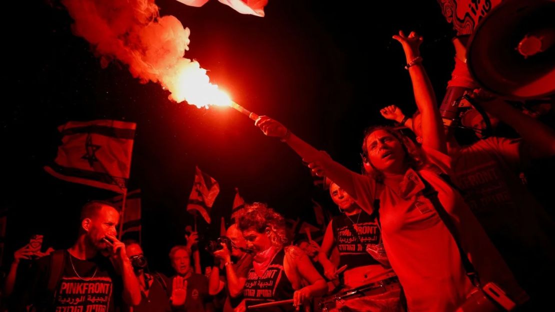 Un manifestante sostiene una bengala durante una manifestación en Tel Aviv el 27 de julio de 2023. Crédito: Amir Cohen/Reuters