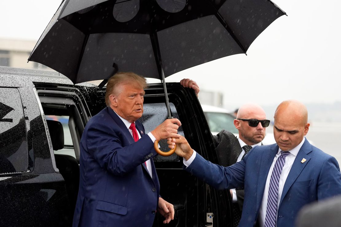 Walt Nauta entrega un paraguas al expresidente Donald Trump en el aeropuerto nacional Ronald Reagan de Washington, el jueves 3 de agosto.