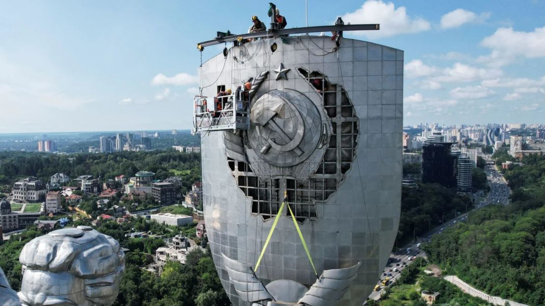 Trabajadores quitan el emblema de la era soviética del Monumento a la Madre Patria en Kyiv el 1 de agosto de 2023.