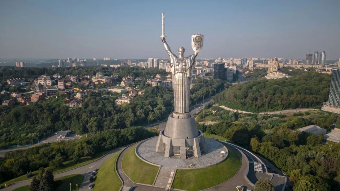 La estatua de acero, fotografiada con el escudo de armas de Ucrania este domingo, es una característica imponente del paisaje urbano de Kyiv.