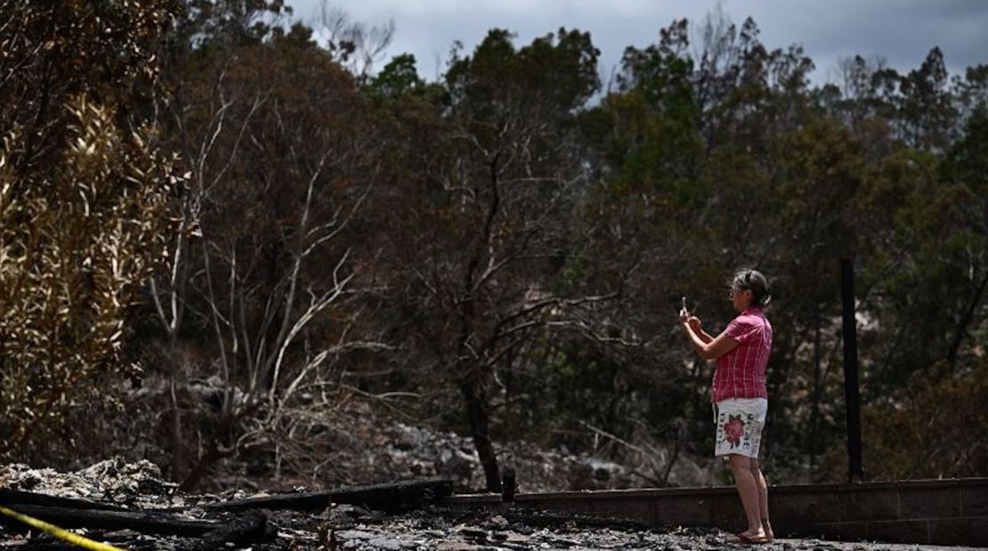 Un cuidador fotografía el sitio de una casa destruida por los incendios forestales de Maui en Kula, Hawái el domingo.