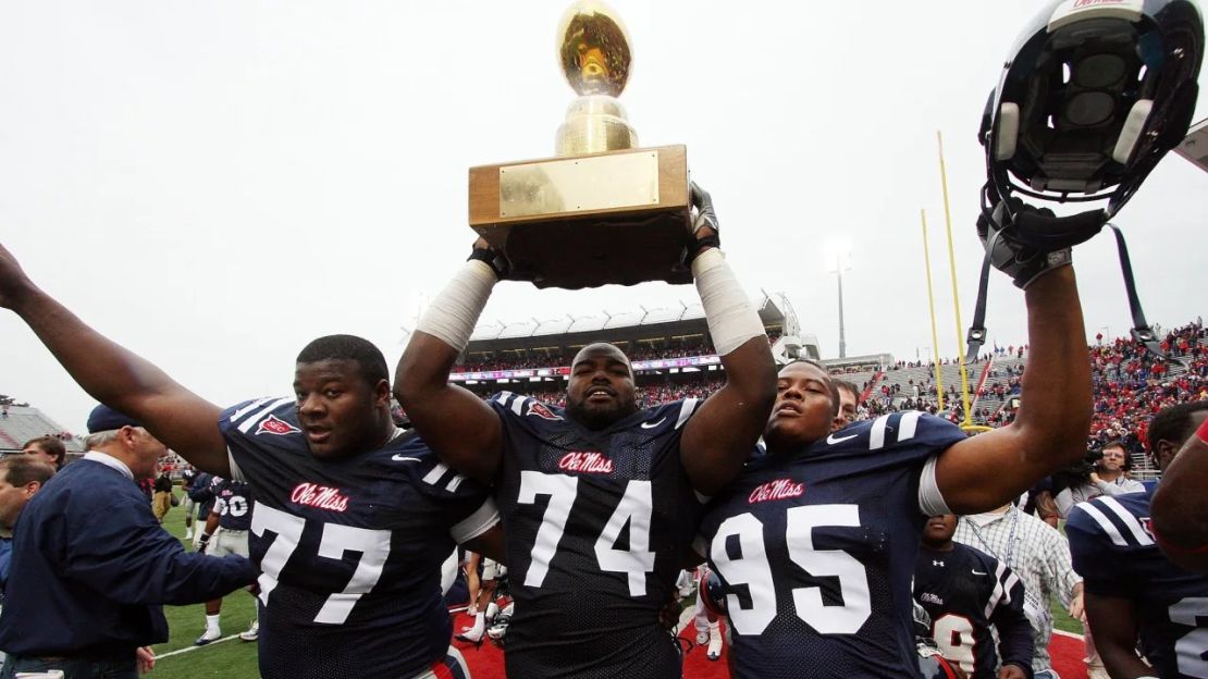 Michael Oher alza el trofeo Golden Egg con sus compañeros de equipo después de que Ole Miss venciera a Mississippi State el 28 de noviembre de 2008, en Oxford, Mississippi. Crédito: Matthew Sharpe/Getty Images