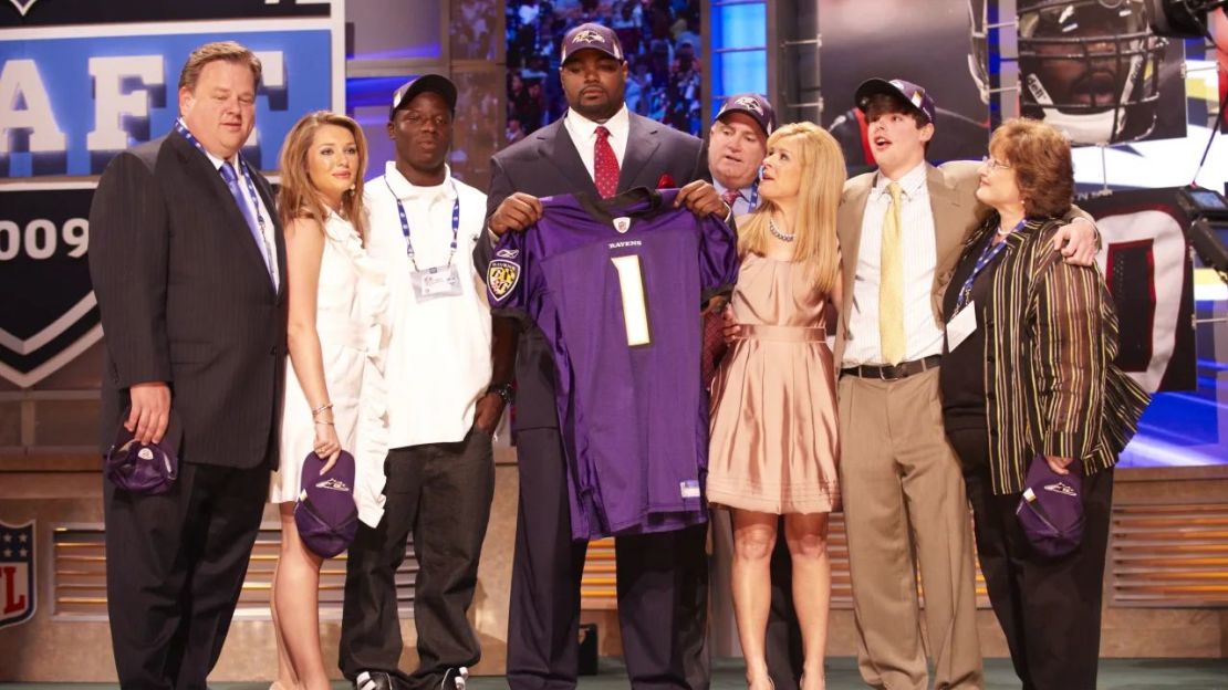 Michael Oher posa con la familia Tuohy y otras personas cuando fue elegido por los Baltimore Ravens en la primera ronda del Draft de la NFL de 2009. Crédito: David Bergman/Sports Illustrated/Getty Images