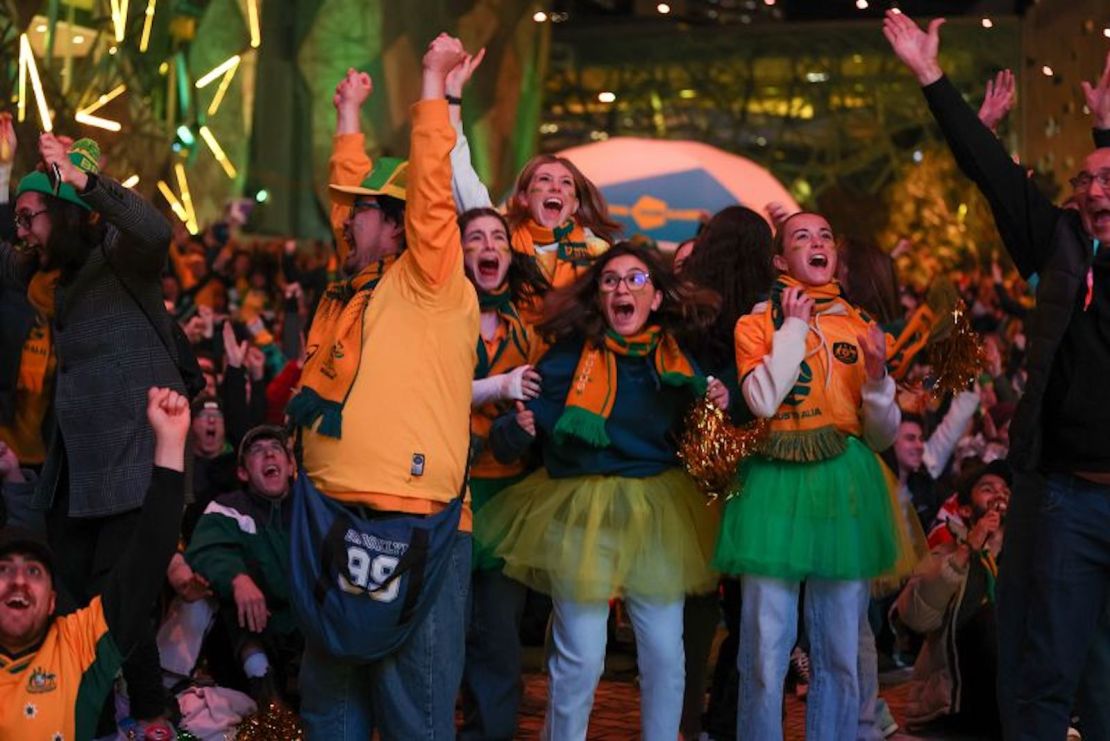 Seguidores australianos celebran en la Plaza de la Federación de Melbourne el primer gol de las Matildas en su partido de octavos de final de la Copa Mundial de la FIFA contra Dinamarca, el 7 de agosto (Fotografía: Asanka Ratnayake/Getty Images).