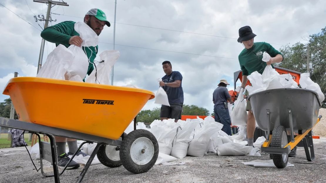 Un equipo ayuda a los residentes con sacos de arena el lunes en Tampa, Florida.