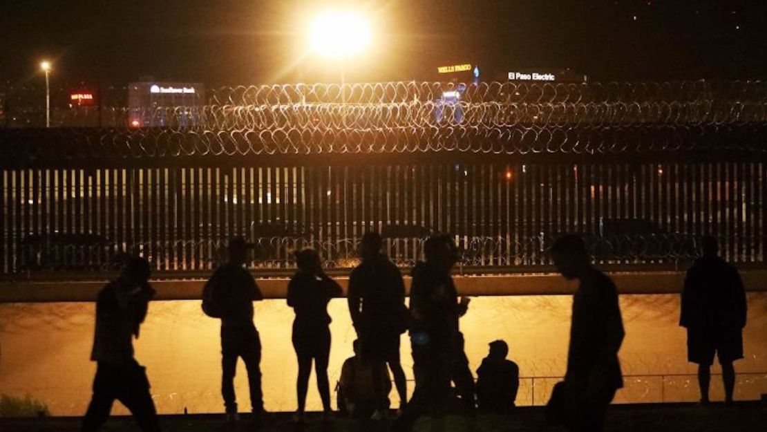 Migrantes guiados por un falso rumor de que Estados Unidos abriría su frontera a la migración irregular el 8 de agosto esperan ser recibidos a través de un puente ferroviario en la frontera entre El Paso, Texas, y Ciudad Juárez, estado de Chihuahua, México, el 7 de agosto de 2023.