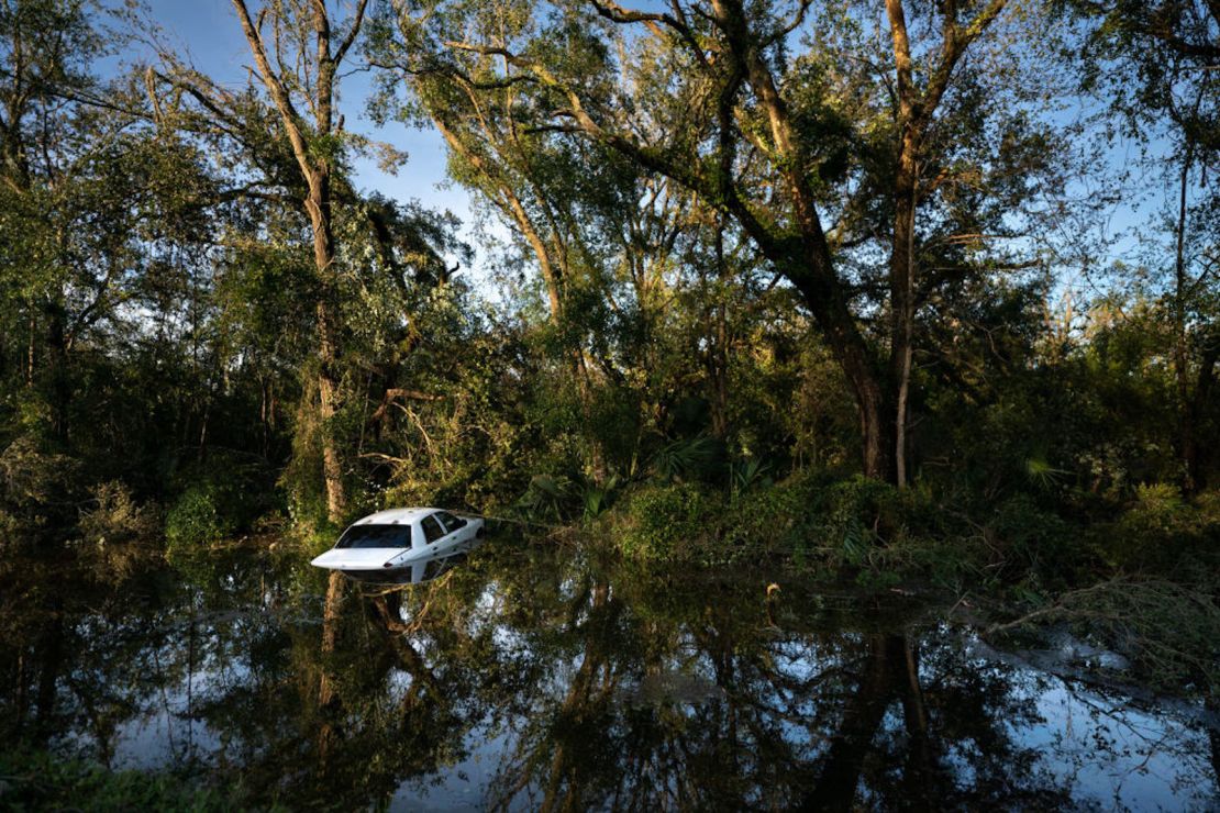 PERRY, FLORIDA - AUGUST 30: Un vehículo que se estrelló tras chocar contra un árbol caído se encuentra en un barranco después de que el huracán Idalia cruzara el estado el 30 de agosto de 2023 en Perry, Florida.