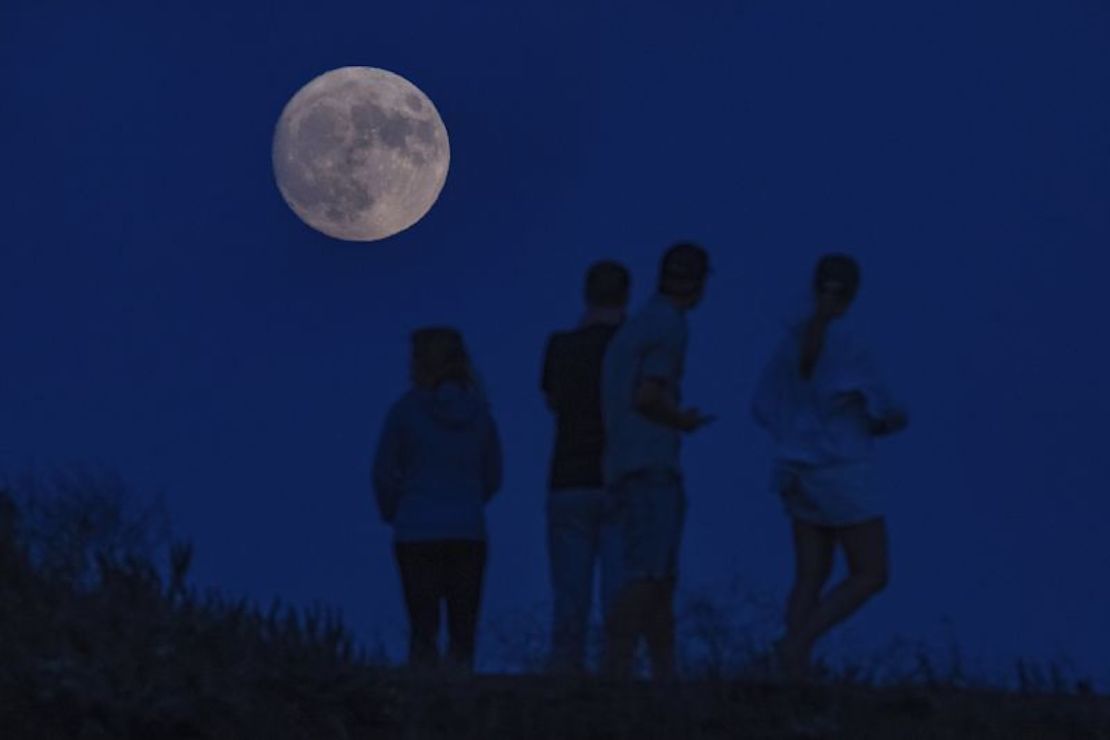 Visitantes se detienen a fotografiar una luna gibosa creciente con un 96% de iluminación en Fort Baker en Sausalito, California, el 29 de agosto.