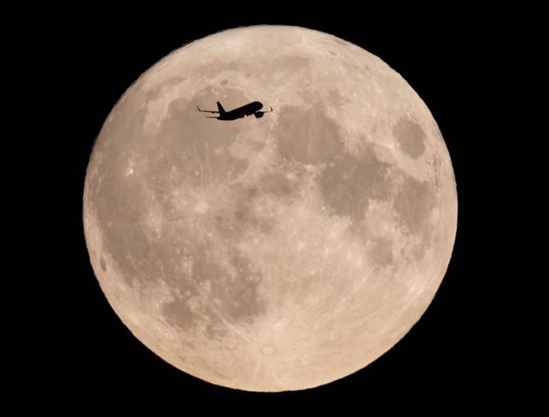 Un avión pasa por delante de una rara superluna azul, en Londres, Inglaterra, el 30 de agosto.