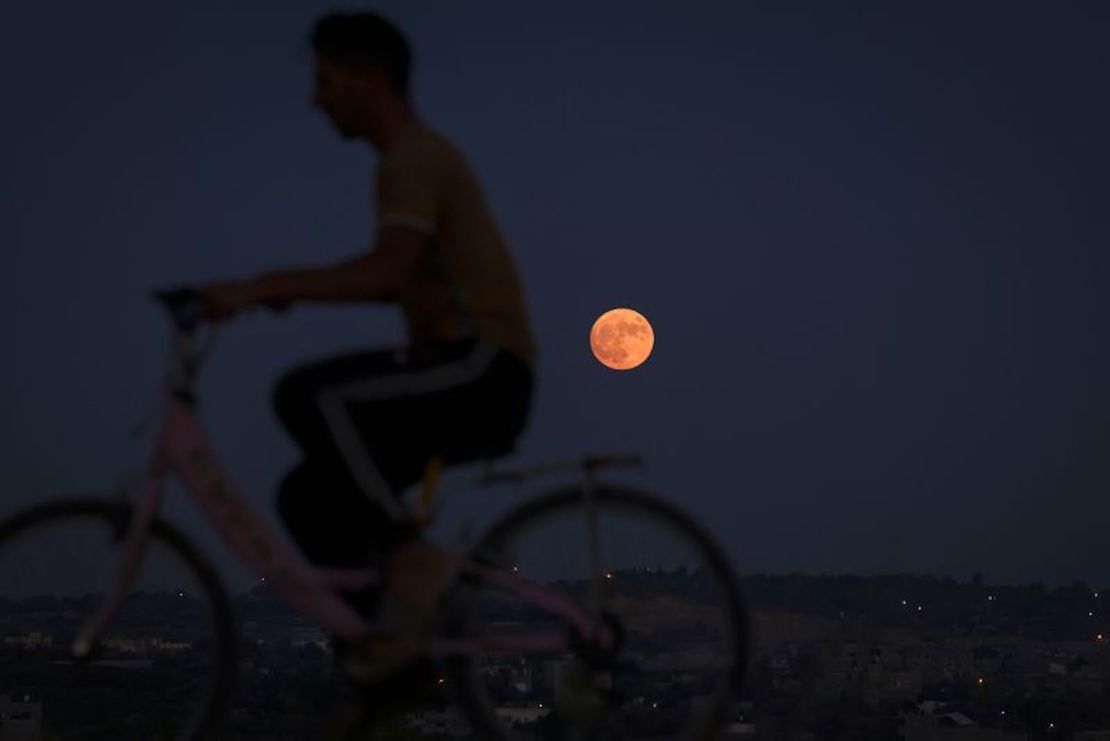 Un hombre monta en bicicleta durante la salida de la luna azul sobre la ciudad de Beit Lahia, en el norte de la Franja de Gaza, el 30 de agosto.