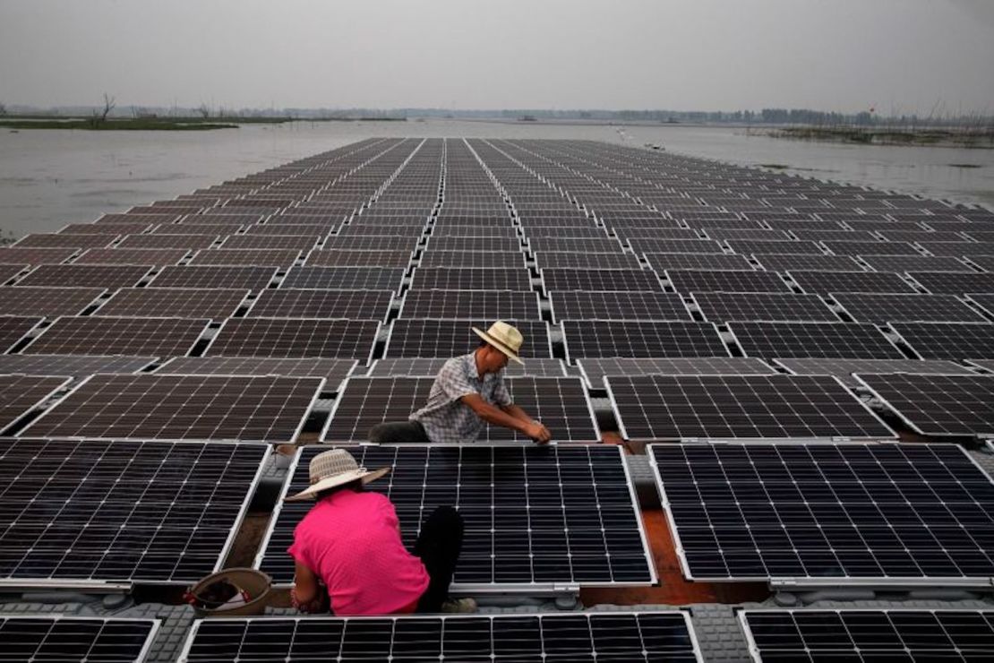 Trabajadores preparan parte de un gran proyecto de granja solar flotante en construcción en junio de 2017 en Huainan, provincia de Anhui, China.