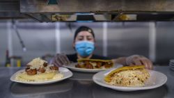 El cocinero Alfredo López prepara arepas en la cocina del restaurante Arepa Lady en el distrito de Queens de la ciudad de Nueva York el 27 de enero de 2022. - En Nueva York, étnicamente rica, puedes cenar fácilmente comida de más de 100 países. Y esa rica mezcla heterogénea quizás se sirva mejor en Queens.