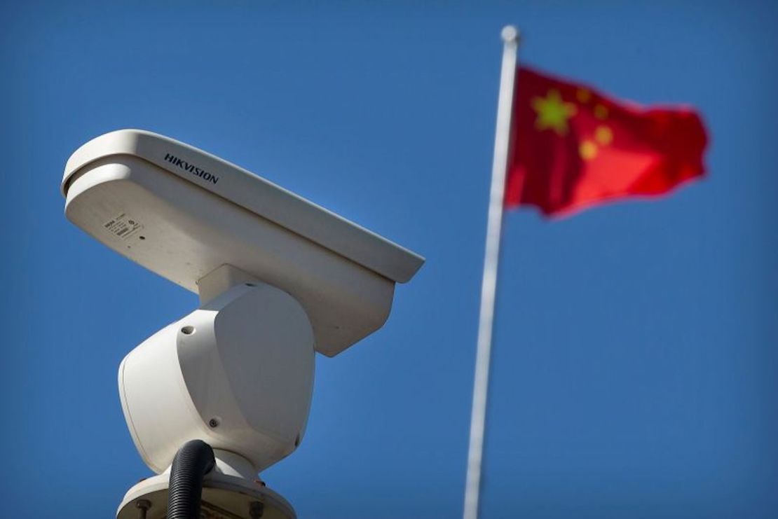 Una bandera china ondea cerca de una cámara de seguridad que monitorea una intersección de tráfico en Beijing, el martes 8 de octubre de 2019.