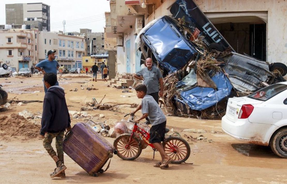 Un niño arrastra una maleta entre los escombros en una zona dañada por una inundación repentina en Derna, este de Libia, el 11 de septiembre de 2023.