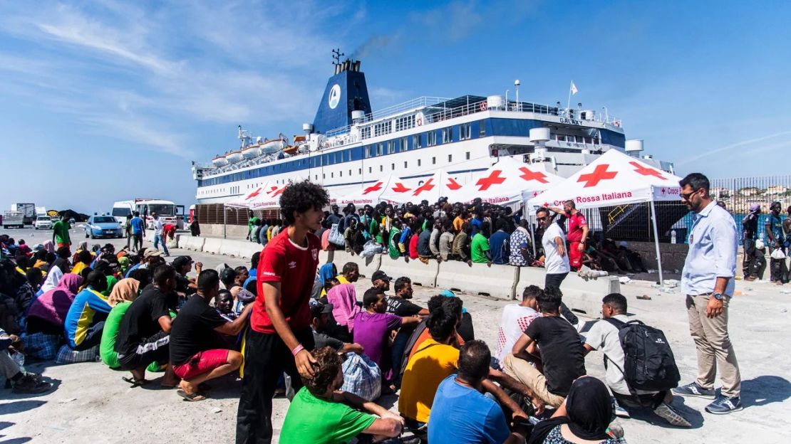 Un agente de seguridad guía a los inmigrantes de un centro de acogida de Lampedusa. Crédito: Alessandro Serranò/AFP/Getty Images