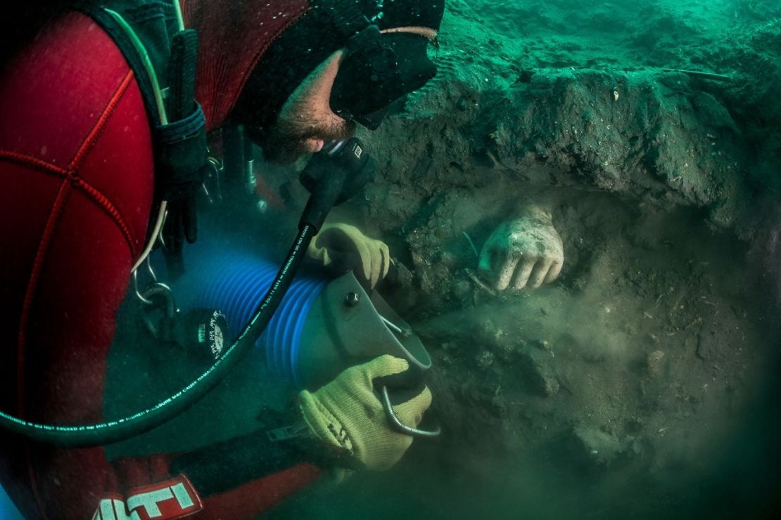 Bucear en Thonis-Hercleion para descubrir tesoros antiguos es una tarea delicada. Se muestra una mano votiva emergiendo del sedimento durante una excavación.