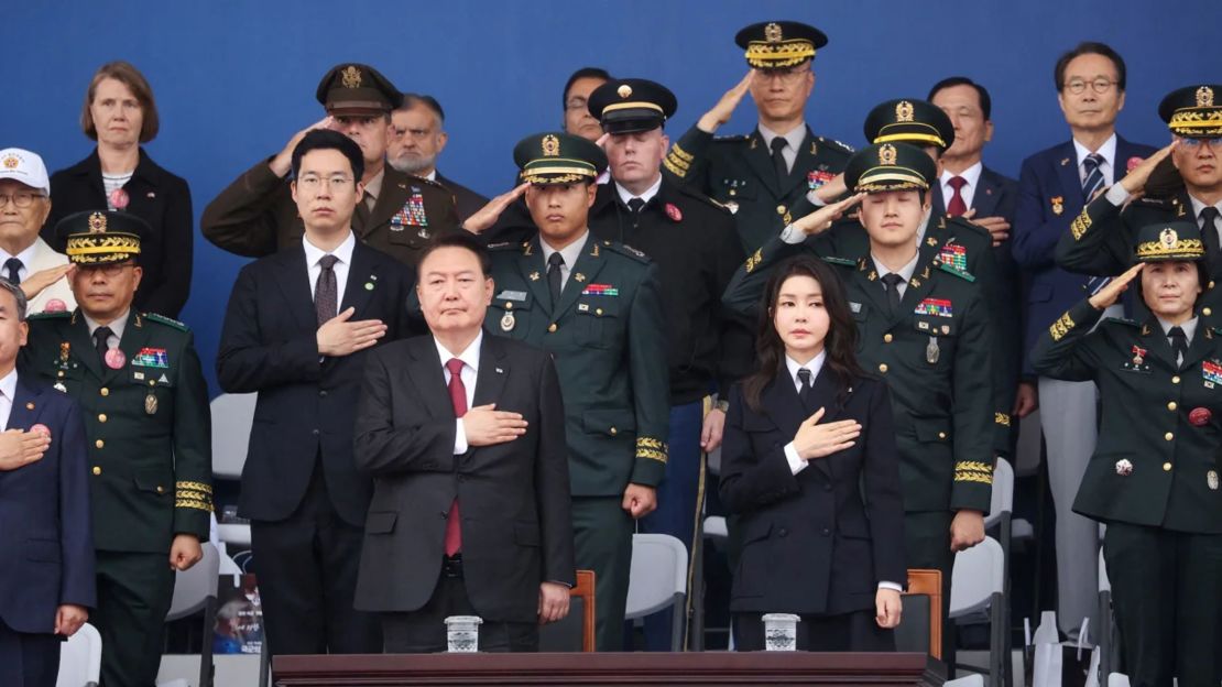 El presidente de Corea del Sur, Yoon Suk Yeol, y su esposa, Kim Keon Hee, saludan la bandera nacional durante el desfile militar.