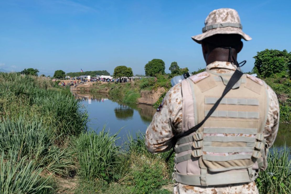 Un soldado dominicano del Cuerpo Especializado de Seguridad Fronteriza Terrestre observa a ciudadanos haitianos durante una operación de militarización en la frontera con Haití cerrada por orden del presidente dominicano Luis Abinader en Dajabón, República Dominicana, el 15 de septiembre de 2023. Crédito: STRINGER/AFP vía Getty Images