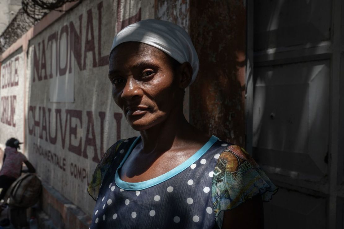 Una mujer haitiana espera a otros de su familia en un asentamiento que antes era una antigua escuela en Puerto Príncipe.