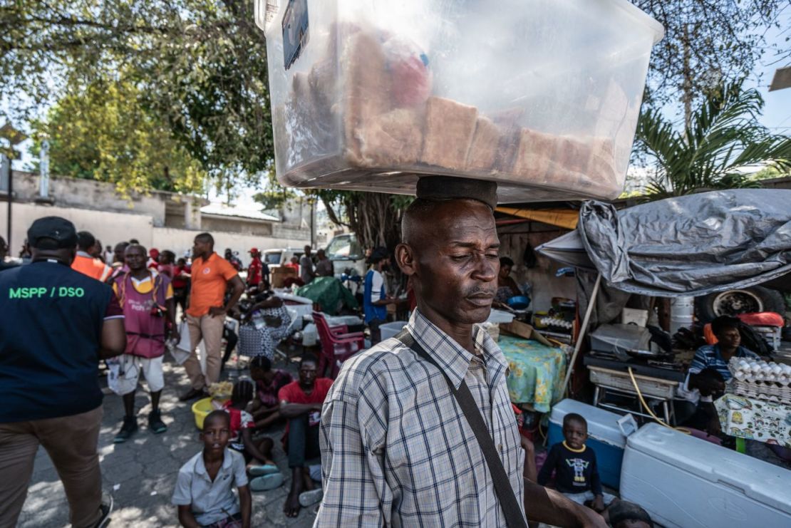 Un hombre lleva sándwiches para vender en un campamento de desplazados en Puerto Príncipe. La inflación ha superado el 50%, dejando a 4,9 millones de haitianos luchando para comer.