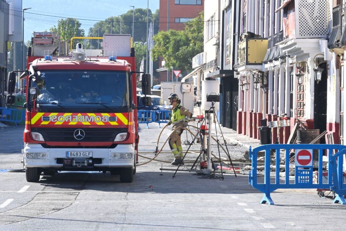 Un bombero sostiene tuberías frente a una discoteca un día después de un incendio que mató al menos a trece personas en una discoteca de Murcia, el 2 de octubre de 2023. Crédito: JOSE JORDAN/AFP vía Getty Images.