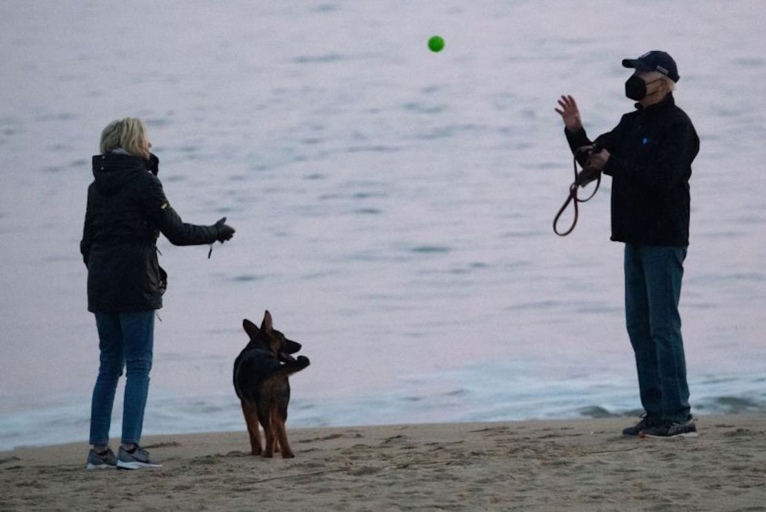 El presidente de Estados Unidos, Joe Biden, y la primera dama de Estados Unidos, Jill Biden, juegan con su perro Commander en Rehoboth Beach, Delaware, el 28 de diciembre de 2021.