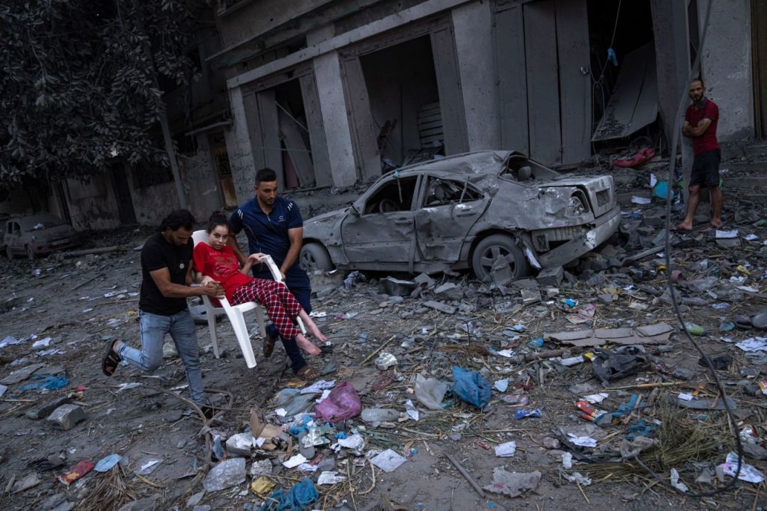 Palestinos pasan entre los escombros tras los ataques aéreos israelíes en la ciudad de Gaza el 10 de octubre.