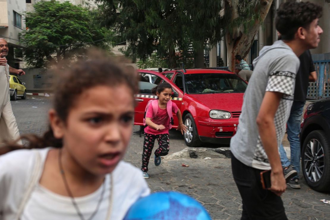 Niñas corren para resguardarse mientras caen bombas cerca del hospital Al-Shifa, en la ciudad de Gaza, el 9 de octubre.