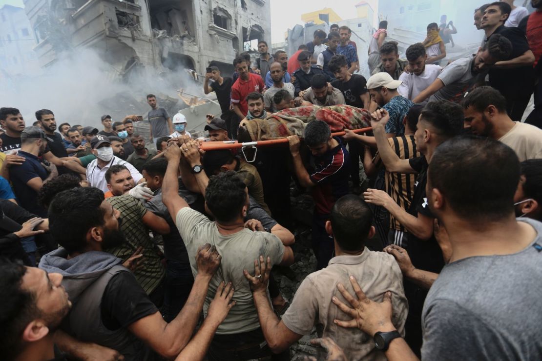 Palestinos retiran un cadáver de entre los escombros de un edificio tras un ataque aéreo israelí contra el campo de refugiados de Jebaliya, en Gaza, el 9 de octubre.