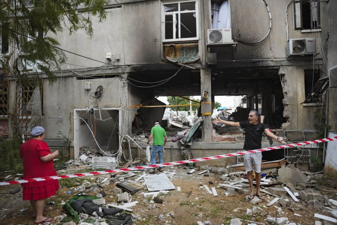 Israelíes observan un edificio residencial dañado en Ashkelon tras ser alcanzado por un misil disparado desde Gaza el 9 de octubre.