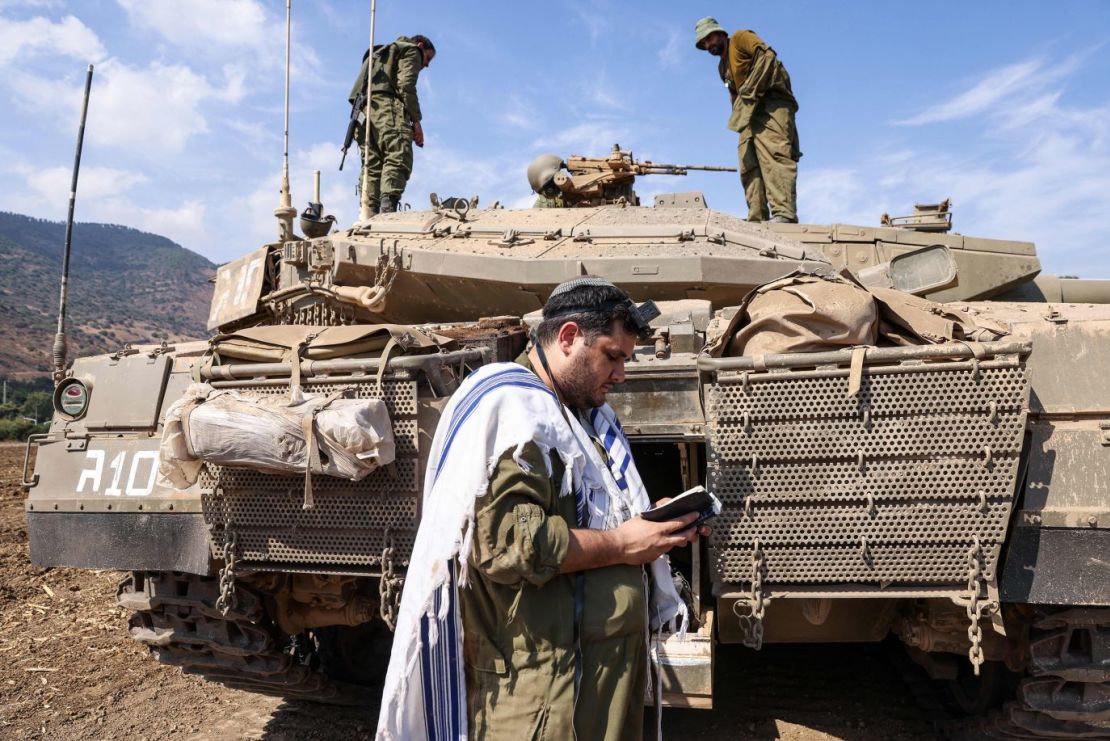 Un soldado israelí reza frente a un tanque en las afueras de la ciudad septentrional de Kiryat Shmona, el 8 de octubre.